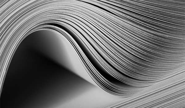Stack of white papers in a curve like someone flipping through a book.